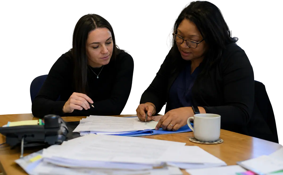 Two compliance professionals reviewing documents